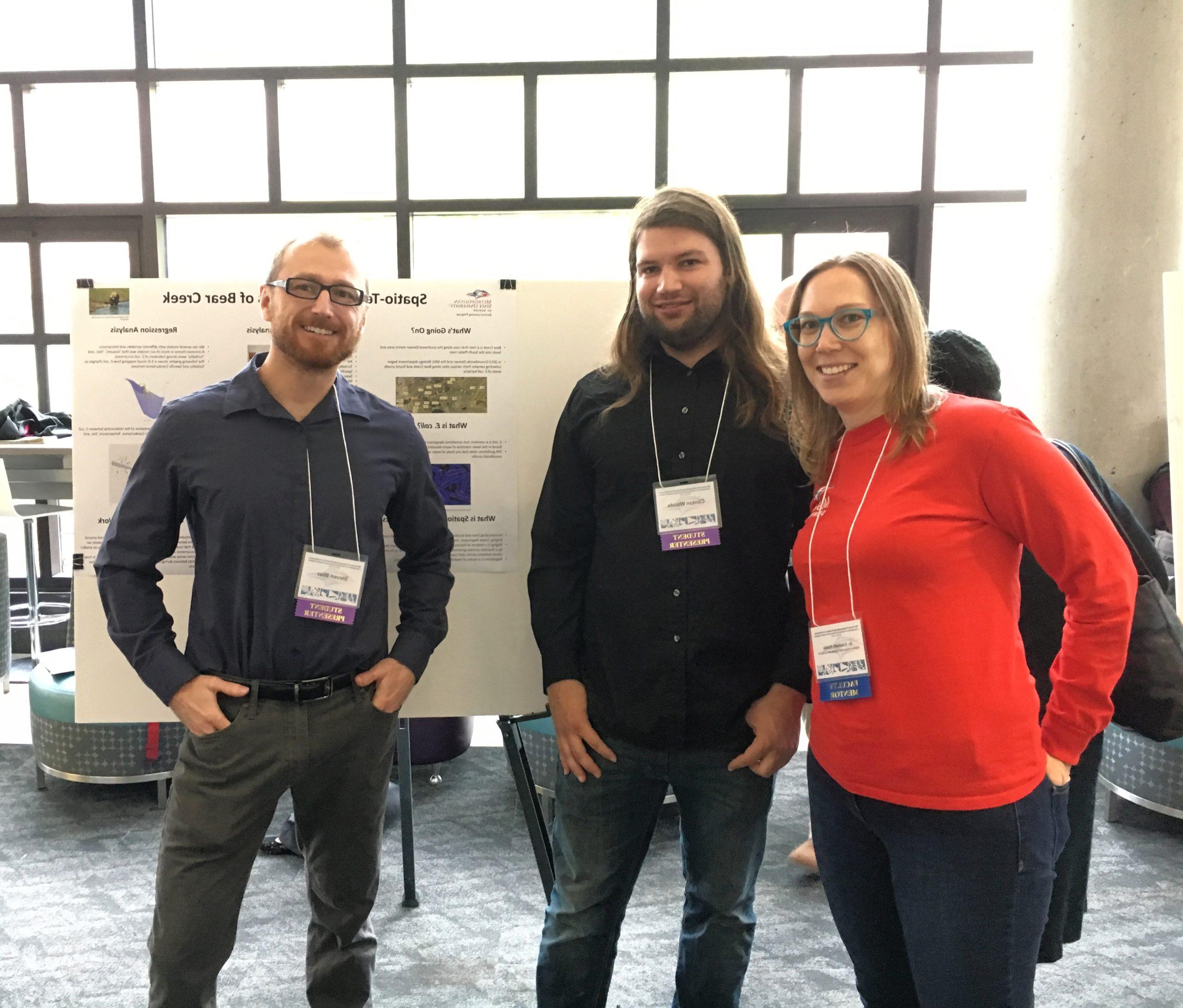 Two student presenters and a faculty mentor at a conference.
