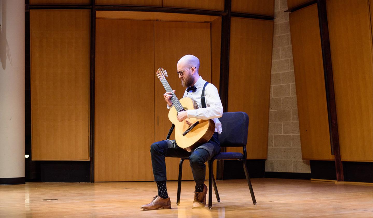 Classical guitarist performing solo in the King Center Recital Hall