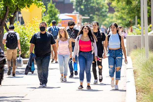 Students walking towards camera outside on Auraria campus during a sunny day