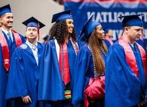 在2023年春季毕业典礼上，密歇根州立大学丹佛分校的毕业生们面带微笑，穿着他们的徽章排队